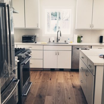 Carranza Construction - a kitchen with white cabinets and wood floors - General Contractors Near Me Carranza Construction - a kitchen with white cabinets and wood floors - General Contractors Near Me