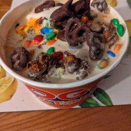a bowl of ice cream with chocolate candies and m & m's