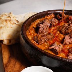 Marash Turkish Cuisine - Pasha Kebab -- slow-braised tender beef over rich Anatolian-style stew, served sizzling with fresh bread and creamy yogurt.