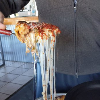 Undisputed Craft House - a man holding a piece of deep dish pizza - Gastropubs Near Me - El Paso, Texas Undisputed Craft House - a man holding a piece of deep dish pizza - Gastropubs Near Me - El Paso, Texas