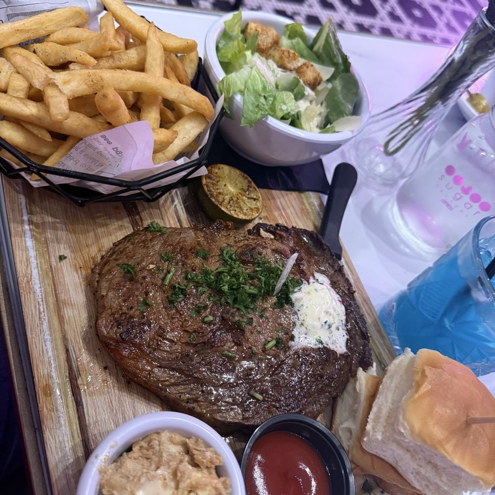 Sugar Factory - Queens - Steak frites 12 of ribeye, signature fries, Caesar Salad, baked sweet rolls, cinnamon-honey butter, ocean blue margarita - Desserts Near Me - Jamaica, New York