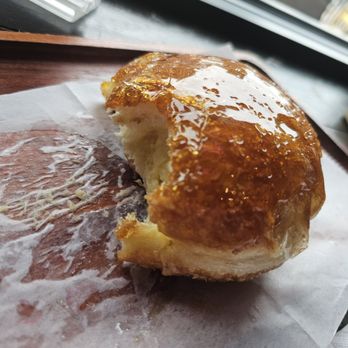 Chateau De Chantilly Cafe - Creme brulee donut, with a bite taken out - Bakeries Near Me - Chantilly, Virginia