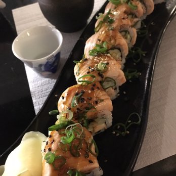 Kokoro - Aburiyaki Salmon Roll - with Nihonshu (Sake) in the background. - Japanese Near Me - Zürich, ZH Kokoro - Aburiyaki Salmon Roll - with Nihonshu (Sake) in the background. - Japanese Near Me - Zürich, ZH