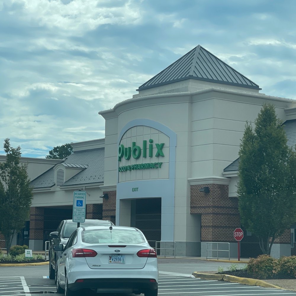 a woman standing in front of a publix store