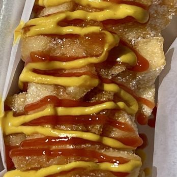 Cafe MiMi - Fried food on a skewer, drizzled with mustard and ketchup, served on white paper. - Cafes Near Me - Madison, Wisconsin