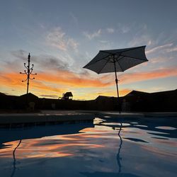 Gomez Pools & Spas - Beautiful evening picture in which you can see the built in table and bench in the pool! Great option!