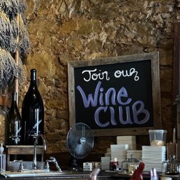 a wine club sign and bottles of wine
