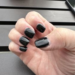 Golden Nails & Spa - Hand with black gel nails.