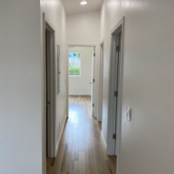 Satisfaction Flooring & Remodeling - a long hallway with hardwood floors - Flooring Near Me Satisfaction Flooring & Remodeling - a long hallway with hardwood floors - Flooring Near Me