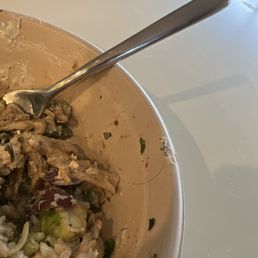 a bowl of food with a spoon in it a bowl of food with a spoon in it