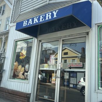 Maple st Bakery - Blink and you can miss it..... - Maple St Bakery's exterior features a glass door with a sign and a large window displaying baked goods, under a blue awning labeled 'BAKERY.' - Bakeries Near Me - Naugatuck, Connecticut