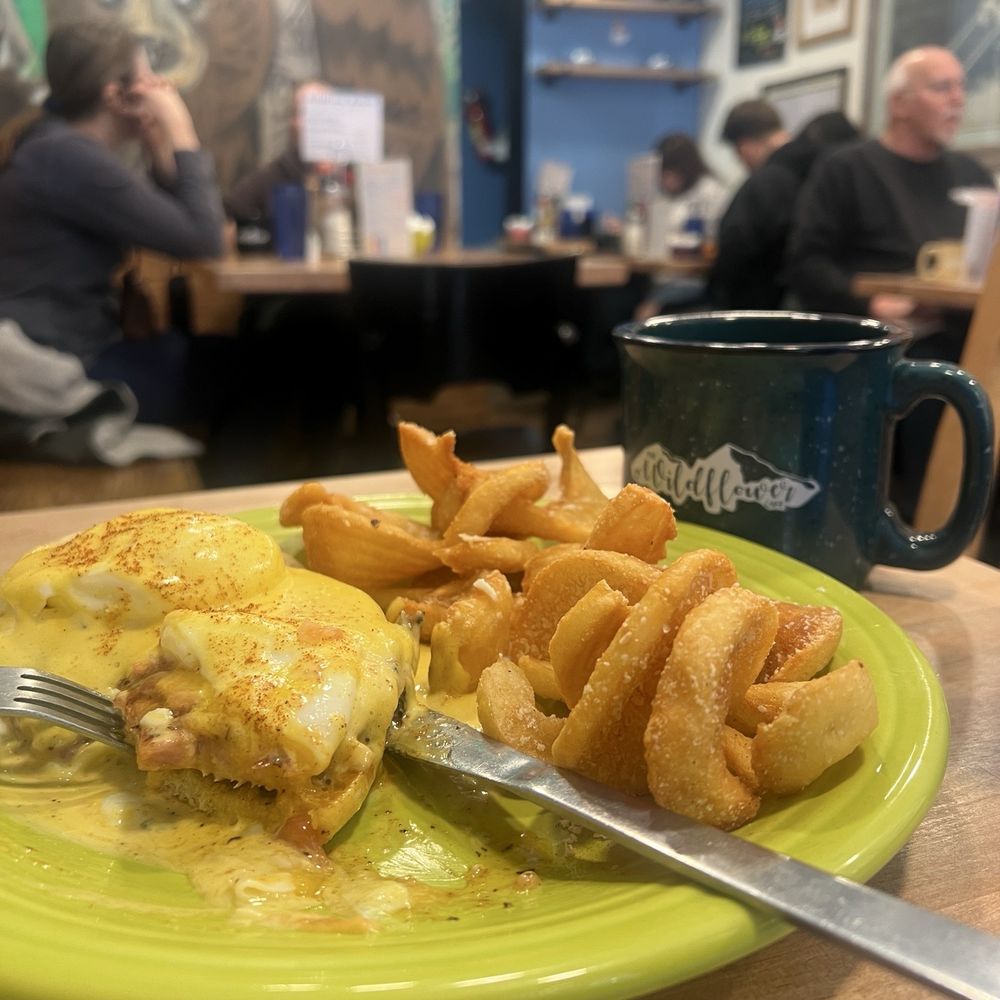 Classic Benedict with black coffee and people in the background Classic Benedict with black coffee and people in the background