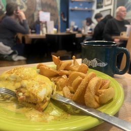 Classic Benedict with black coffee and people in the background