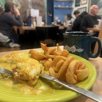Wildflower Cafe - Classic Benedict with black coffee and people in the background - Breakfast & Brunch Near Me - Evergreen, Colorado