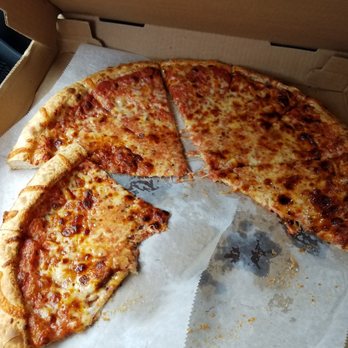 Woonsocket Palace Pizza - A cheese pizza with a golden crust, some slices missing, in a cardboard pizza box with parchment paper. - Pizza Near Me - Woonsocket, Rhode Island