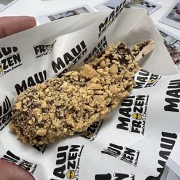 Chocolate dipped frozen banana with peanuts. Ono