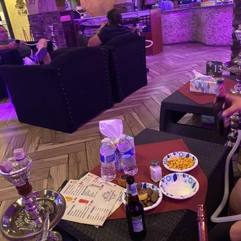 Al-Keif - a woman sitting at a table in a restaurant - Hookah Bars Near Me - Worth, Illinois