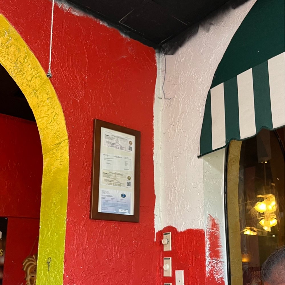 The wall is half painted, and the ceiling paint is all over the wall The wall is half painted, and the ceiling paint is all over the wall