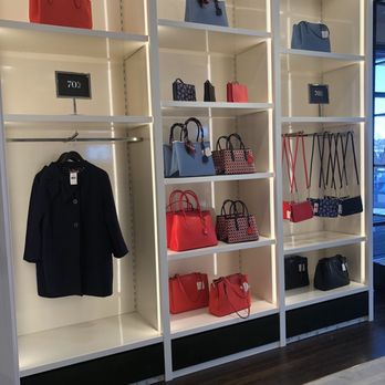 Denver Premium Outlets - Shelves showcase handbags, purses, and a black coat, with signs indicating a 70% discount at a retail store. - Outlet Stores Near Me - Thornton, Colorado