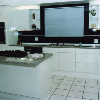 Dreamworks Construction - a kitchen with white cabinets and black countertops - General Contractors Near Me Dreamworks Construction - a kitchen with white cabinets and black countertops - General Contractors Near Me