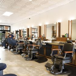 The Carpenters Chair Barbershop - Barbershop floor view showing multiple stations for fades, tapers, and classic men's hairstyles.