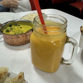 Naan N Curry - Mango Lassi with Madras Mixed Vegetable Curry in background. You can also seen part of the naan. - Indian Near Me - Portland, Oregon Naan N Curry - Mango Lassi with Madras Mixed Vegetable Curry in background. You can also seen part of the naan. - Indian Near Me - Portland, Oregon
