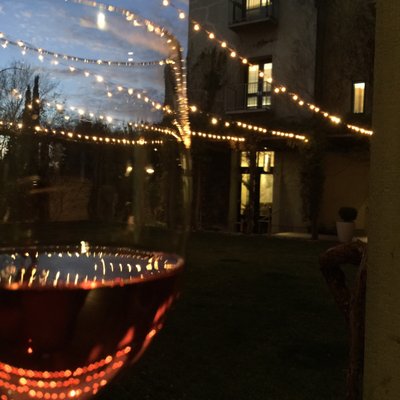 Photo of Dry Creek Kitchen - Healdsburg, CA, US. The lights over the grassy courtyard with the Pinot Rosè they were serving