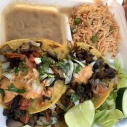 Vegan taco topped with mushroom asada, salad, Spanish rice, and beans Vegan taco topped with mushroom asada, salad, Spanish rice, and beans