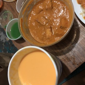 Ashoka Grill - a wooden table with a bowl of curry and plates of food - Indian Near Me - Brooklyn, New York Ashoka Grill - a wooden table with a bowl of curry and plates of food - Indian Near Me - Brooklyn, New York