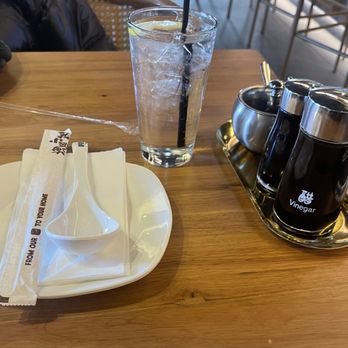 Ugly Dumpling - Table set up complete with ginger soy sauce and sesame hot sauce. I love that.  Water came with lemon - Noodles Near Me - Bronx, New York