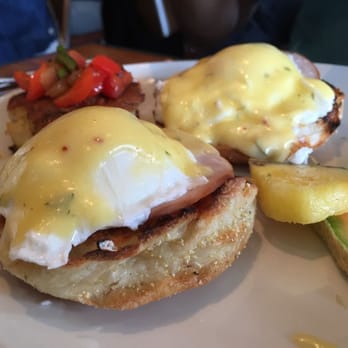 Grace's Table - Creamy perfectly-poached eggs benedict, potato in the background with sauteed peppers/onions. - New American Near Me - Napa, California