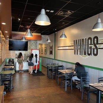 Wingstop - people sitting at tables in a restaurant - Chicken Wings Near Me - Boise, Idaho Wingstop - people sitting at tables in a restaurant - Chicken Wings Near Me - Boise, Idaho