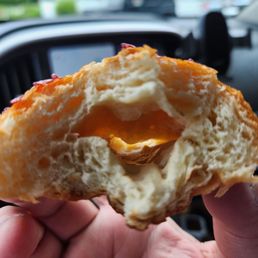 a person holding a half eaten pastry a person holding a half eaten pastry