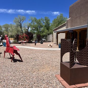 Cafe Abiquiu - Beautiful day to visit Abiquiú - Open outdoor space with various sculptures, trees, and a building labeled 'Abiquiu Inn' in New Mexico. - Mexican Near Me - Abiquiu, New Mexico