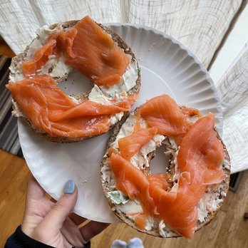 Bagels-4-U - Livingston - ows a person holding a bagel with salmon on it - Bagels Near Me - Livingston, New Jersey Bagels-4-U - Livingston - ows a person holding a bagel with salmon on it - Bagels Near Me - Livingston, New Jersey
