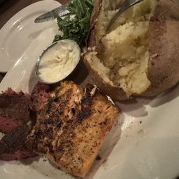 My Filet Mignon (undercooked) and my guy's salmon. Both already eaten on (portions were larger) and a baked potato. My Filet Mignon (undercooked) and my guy's salmon. Both already eaten on (portions were larger) and a baked potato.