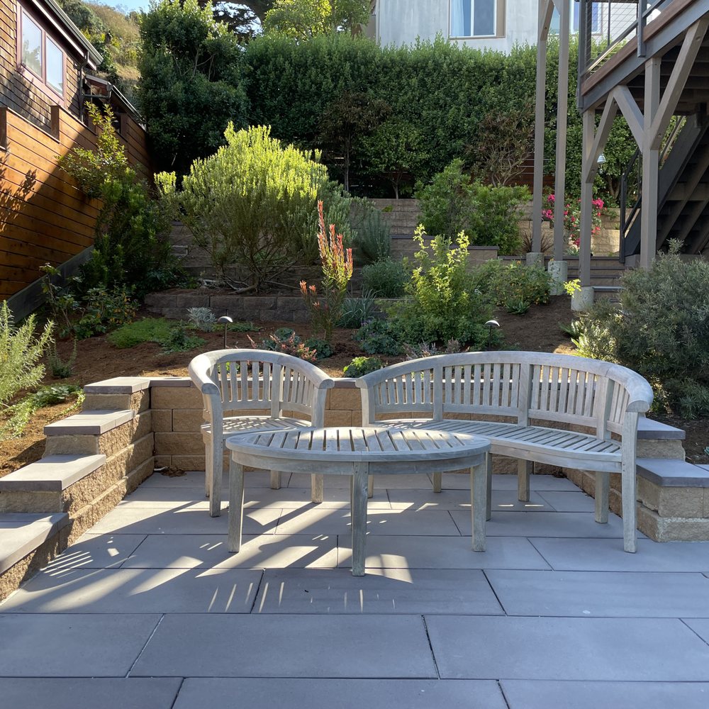 a patio with a bench and steps a patio with a bench and steps