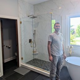Extended shower wall - primary bathroom with owner Astrit.