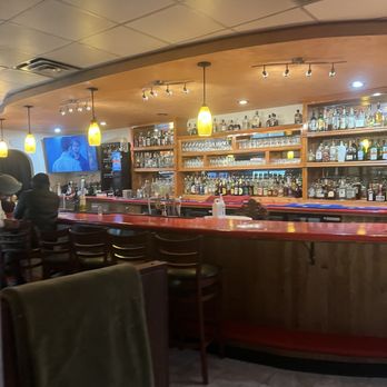 Royal India Grill - Bar seating and view of selves with variety of alcoholic drinks bottles - Indian Near Me - Hamilton, New York