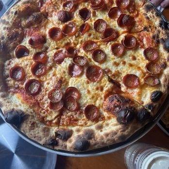 Cowabunga - Pepperoni - A pepperoni pizza with melted cheese and pepperoni slices, served on a metal tray, with drinks and condiments nearby. - Pizza Near Me - Hamilton, Ontario