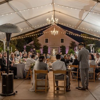 Scribner Bend Vineyards - a group of people sitting at tables under a tent - Venues & Event Spaces Near Me - Sacramento, California