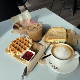 Waffle with fresh jam, egg and spinach sando, oat cappuccino and dirty Colombian