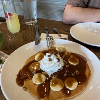 Another Broken Egg Cafe - Banana Foster pancake Peep the mimosa in the back. - American Near Me - Austin, Texas Another Broken Egg Cafe - Banana Foster pancake Peep the mimosa in the back. - American Near Me - Austin, Texas