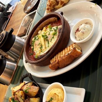 Medina Cafe - Potatoes, tadig with lamb sausage and waffles with berry compote and a white chocolate pistachio rose water sauce - Breakfast & Brunch Near Me - Vancouver, British Columbia