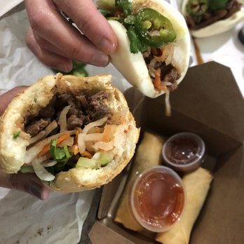 Banh Mi Pho Wings - a person holding a sandwich - Vietnamese Near Me - Austin, Texas