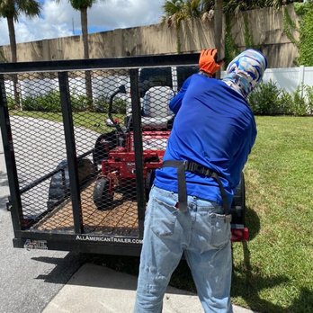 Sabal Palm Lawn Services - a man in a blue shirt and orange helmet working on a utility trailer - Lawn Services Near Me - Tamarac, Florida Sabal Palm Lawn Services - a man in a blue shirt and orange helmet working on a utility trailer - Lawn Services Near Me - Tamarac, Florida