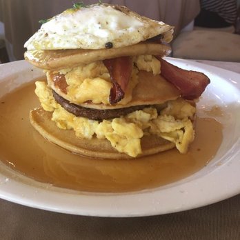 Restaurant506 - Breakfast tower-scrambled eggs, bacon and sausage layered between 3 pancakes with and over medium egg on top - New American Near Me - Arlington, Texas