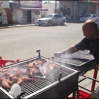 Molcas Tacos - The chef grills chicken on a wood-fired grill, on the sidewalk in front of the restaurant. - Northern Mexican Near Me - Los Algodones, BCN Molcas Tacos - The chef grills chicken on a wood-fired grill, on the sidewalk in front of the restaurant. - Northern Mexican Near Me - Los Algodones, BCN