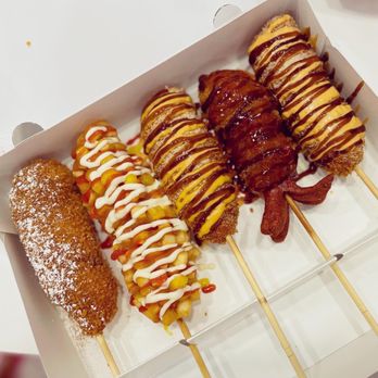 Chung Chun Rice Dog - From left to right: chocolate, gamsung (potato hot dog), mozzarella cheese, squid ink and whole mozarella cheese - Korean Near Me - Mississauga, Ontario Chung Chun Rice Dog - From left to right: chocolate, gamsung (potato hot dog), mozzarella cheese, squid ink and whole mozarella cheese - Korean Near Me - Mississauga, Ontario