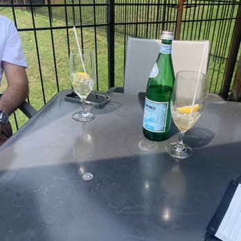 Kelly's Landing - a man sitting at a table with two wine glasses and a bottle - Canadian (New) Near Me - Manotick, Ontario
